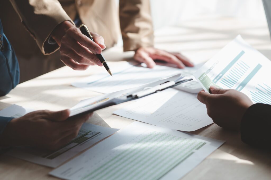 Businessman is reviewing monthly sales documents for analysis.